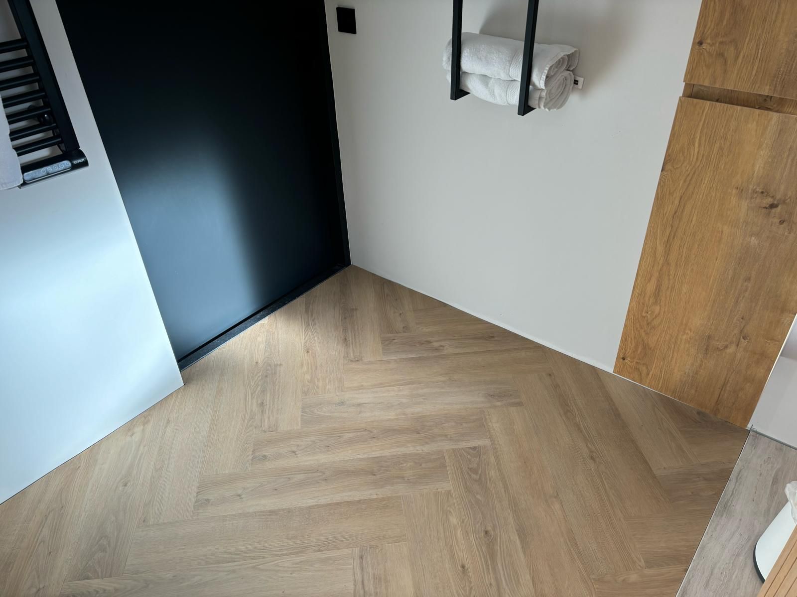 Visgraatvloer in een badkamer met zwarte accenten