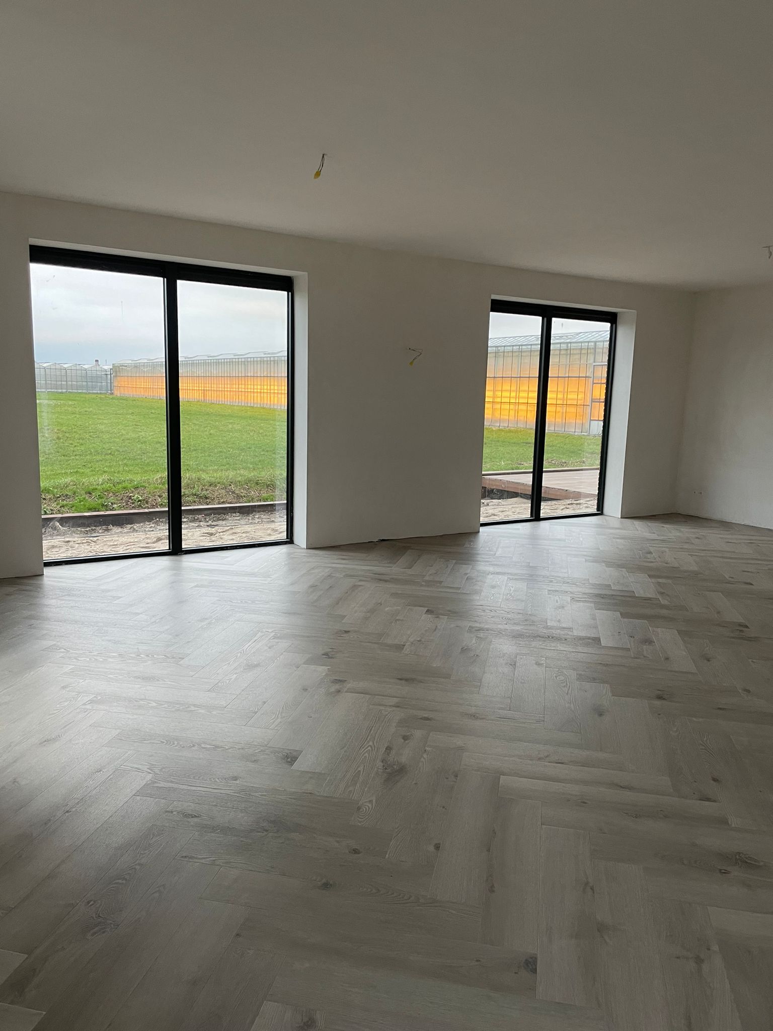 Lichte visgraatvloer in een ruime woonkamer met groot raam